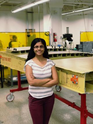 Krithika stands next to a model wing at the Boeing Advanced Research Center at UW.