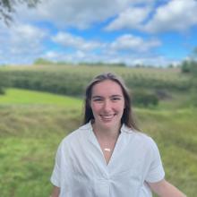 Portrait of Ella in front of trees and a blue sky 
